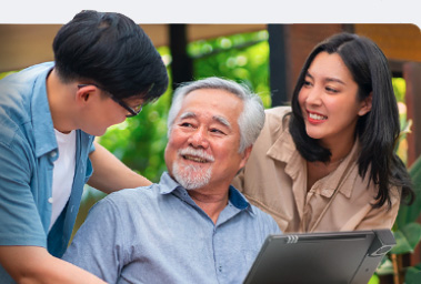 Younger people helping an older man with a telephone